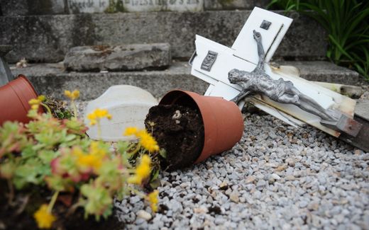 A  damaged crucifix on the ground after Christian tombstones were found vandalized in France. Photo AFP, Remy Gabalda