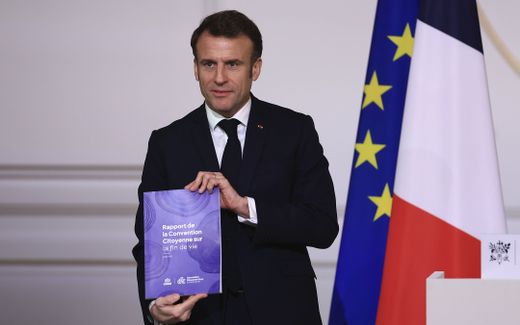 

French President Emmanuel Macron poses with the document on the end-of-life options after a panel of citizens worked on the issue in recent months. Photo EPA, Aurelien Morissard