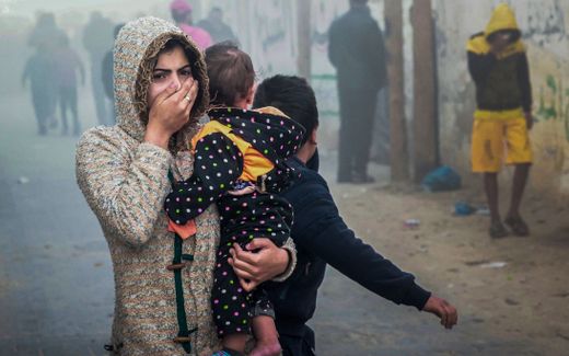 A woman holding a child flees following an Israeli strike in Rafah in the southern Gaza Strip. Photo AFP, Mohammed Abed
