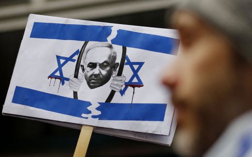 A picture of Israel's Prime Minister Benjamin Netanyahu behind bars is seen as members of the Israeli and Jewish community gather to protest outside the Israeli Consulate in New York. Photo AFP, Leonardo Munoz
