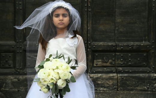 A young actress plays the role of a child bride forced to marry a much older man, during a happening organised by Amnesty International to denounce child marriage. Photo AFP, Gabriel Bouys
