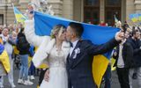 A wedding couple kiss as they celebrate together with Ukrainians who lived in Kherson and left it due to the Russian occupation in downtown of the South Ukrainian city of Odesa. Photo EPA, STR
