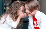 Children whispering to each other. Photo Unsplash