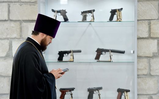 An Orthodox priest visits an exhibition of weapons. Photo AFP, Sergei Gapon
