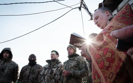 Chaplain conducts a prayer for Ukrainian servicemen before their departure to the frontline in the Donetsk region. Photo AFP, Yasuyoshi Chiba.
