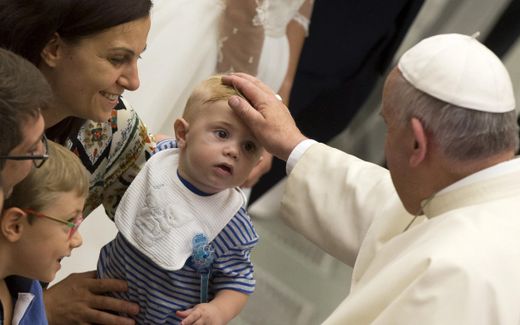 Pope Francis blesses a child. Photo EPA, Claudio Peri
