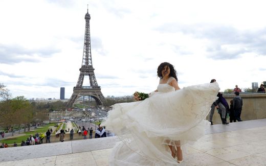 A newly married bride poses in front of the Eiffel tower. Photo AFP, Miguel Medina
