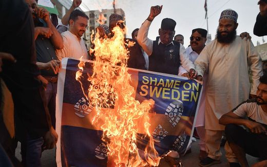 Demonstrators burn a mock Swedish flag as they attend a protest against the burning of a copy of the Koran in Sweden. Photo EPA, Shahzaib Akber