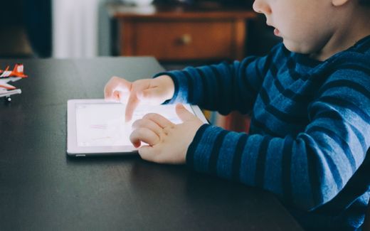 A child playing games on a tablet. Phot Unsplash, Kelly Sikkema  