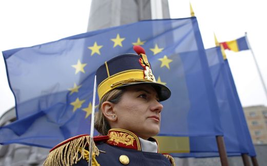 A Romanian Honor Guard female soldier, backed by the European Union flag, stand still for the Iraq and Afghanistan war victims, during a commemoration ceremony held at the Fallen Heroes Memorial, part of the celebrations for the day of Saint George, the patron saint of Romanian Land Forces, in Bucharest, Romania. Photo EPA, Robert Ghement 