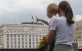 A mother shows her child the Russian Defence Ministry building in Moscow. Photo EPA, Maxim Shipenkov