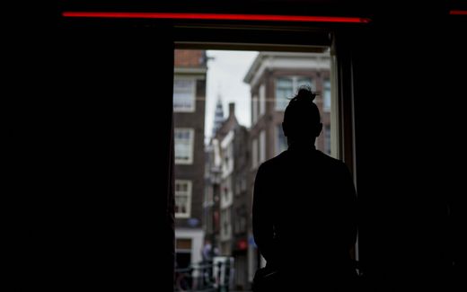 A prostitute waits for clients behind a window in the red light district of Amsterdam. Photo AFP, Kenzo Tribouillard
