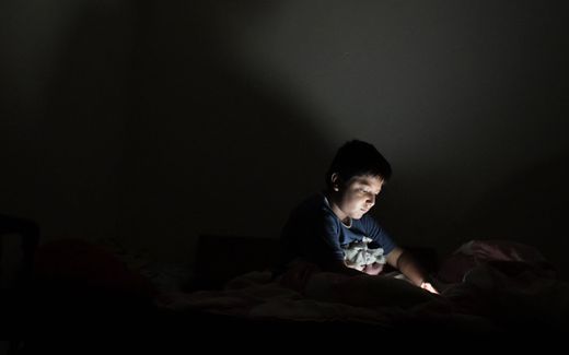 A boy with his mobile phone in the bedroom. Photo AFP, Marvin Recinos
