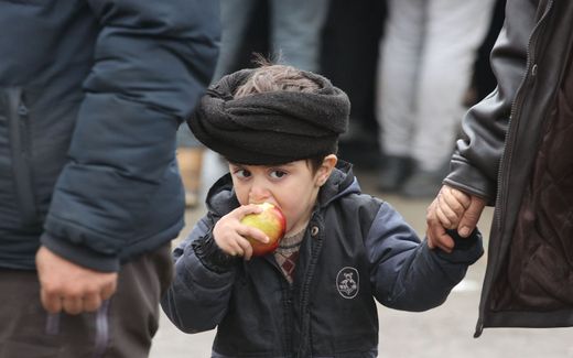 An apple for a migrant boy. As Christians, we cannot look away, says Wolfgang Stock. Photo AFP, Leonid Shcheglov
