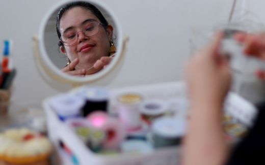 Silvana Escobar, a person with Down syndrome, works making accessories at home. Photo EPA, Carlos Ortega