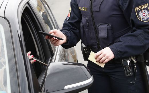 An Austrian police officer checks a driver's digital vaccination certificate on a smartphone during a traffic control at the Südring in Klagenfurt, Austria. Photo AFP, Gert Eggenberger


