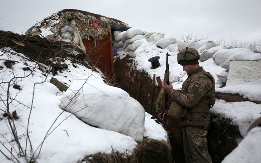 A Ukrainian Military Forces serviceman checks his weapon as he stands in a trench on the frontline with the Russia-backed separatists near Zolote village, in the eastern Lugansk region, on 21 January. Photo AFP, Anatolii Stepanov