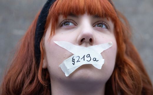 A woman taping her mouths with letters reading '219a' participates in a demonstration for the abolition of criminal code 219a. Photo EPA, Hayoung Jeon