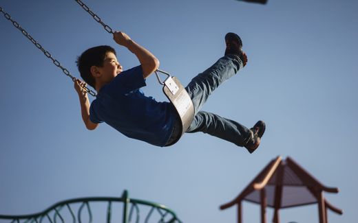 Child on a swing. Photo Unsplash, Myles Tan 