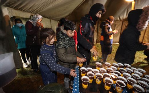 Migrants aiming to cross into Poland receive meals in a camp near the Bruzgi-Kuznica border crossing on the Belarusian-Polish border. Photo AFP, Maxim Guchek