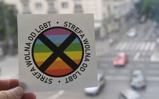 A picture taken on July 24, 2019 in Warsaw shows a sticker bearing a large black cross over an LGBT+ rainbow motif and reading "This is an LGBT-free zone". Photo AFP, Janek Skarzynski