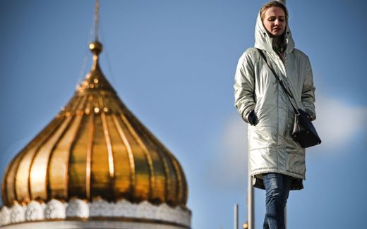 A woman walks in front of Christ the Saviour cathedral, the main Russian Orthodox church in central Moscow. image AFP, Alexander Nemenov