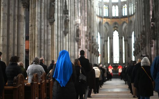 A nun together with other believers attends a mass. Photo AFP, Ina Fassbender
