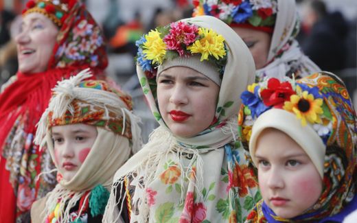 Ukrainians weared traditional costumes look on or sing Christmas carols during a Christmas celebration in Kyiv. Photo EPA, Sergey Dolzhenko