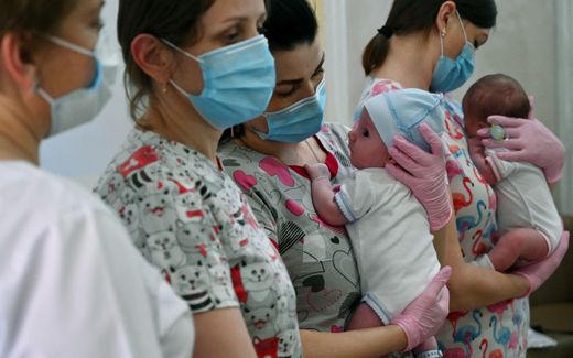 Nurses hold babies as foreign couples gather to collect them in the hotel Venice in the Ukrainian capital of Kiev on June 10, 2020. Eight foreign couples picked up their babies born to Ukrainian surrogate mothers. Photo AFP, Sergei Supinsky
