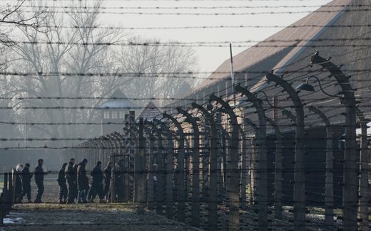 Visitors walk across the barbed wire fences of the Auschwitz. Photo AFP, Janek Skarzynski