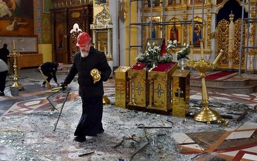 An Orthodox priest collects religous objects as others clear up glass and debris inside a cathedral damaged after missile strikes. Photo AFP, Andriy Andriyenko