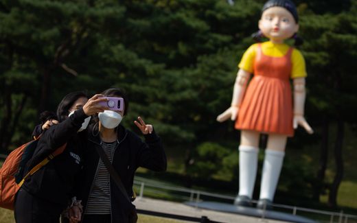 People take a selfie with an episode 1 Robot Doll (named 'Younghee') of the Squid game, in the Olympic park in Seoul, South Korea. Photo EPA, Jeon Heon-Kyun