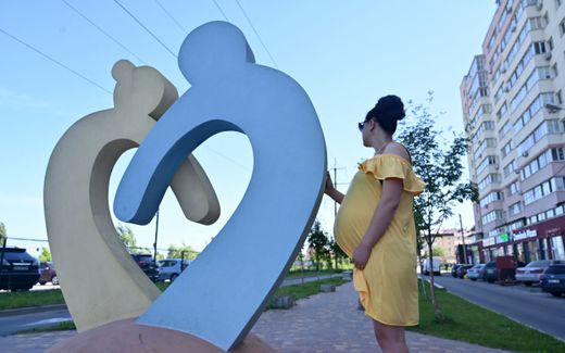 In this photograph taken on June 12, 2020, Olga, a 26-year-old going through her second surrogacy and expecting twins for a Chinese couple, holds her belly as she walks in the small town of Sophiya Borshchagivka, near Kiev. Photo AFP, Sergei Supinsky